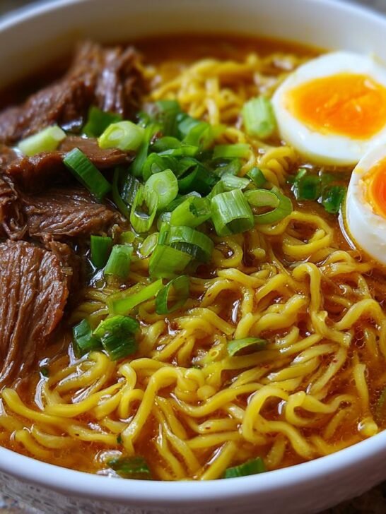 Close-up of a bowl of amazing Beef Ramen Noodles with tender shredded beef, ramen noodles, and soft-boiled eggs.