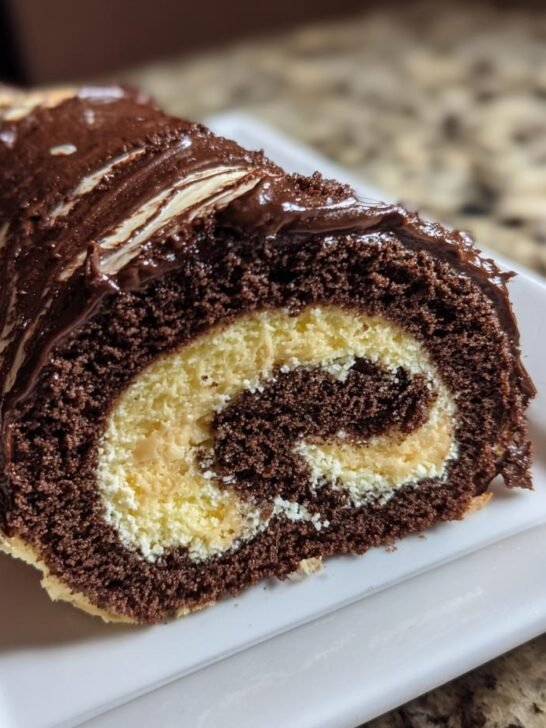 Close-up of a slice of Chocolate Peanut Butter Cake Roll showing the dark chocolate cake swirled with peanut butter filling.