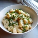 A close-up of Creamy Miso Butter Beans coated in a rich white sauce and topped with fresh parsley.