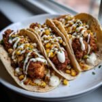Three delicious Fried Chicken Street Corn Tacos topped with charred corn and drizzled with white jalapeno lime ranch.