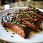 Close-up of medium-rare Garlic Butter Brazilian Steak, sliced and drizzled with garlic butter sauce and fresh parsley.
