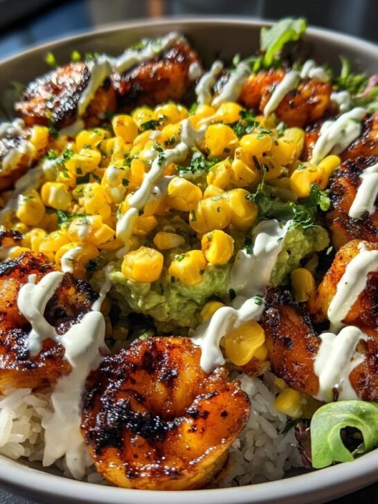 Close-up of a vibrant Grilled Shrimp Bowl With Avocado Corn Salsa, featuring grilled shrimp over rice and greens.
