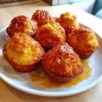 Close-up of six golden Honey Butter Cornbread Poppers drizzled generously with shiny honey butter glaze.