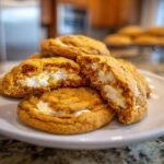 Close-up of Irresistible Pumpkin Cheesecake Cookies, showing the soft orange pumpkin cookie exterior and creamy white cheesecake filling.