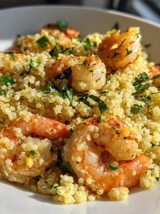 Close-up of bright Lemon Garlic Shrimp Quinoa topped with fresh parsley in a white bowl.