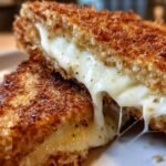 Close-up of Mozzarella In Carrozza cut in half, showing melted, stretching mozzarella cheese.