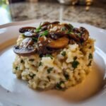 A creamy mound of Mushroom Sage Risotto topped with saut&eacute;ed mushrooms and grated cheese.