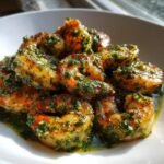 A close-up of perfectly cooked Pan Seared Chimichurri Shrimp piled high and glistening with bright green herb sauce.