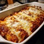 Close-up of baked Pizza Enchiladas Ground Beef covered in melted, bubbly cheese and rich red sauce.
