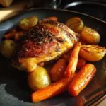 A close-up of perfectly Roasted Garlic Chicken And Vegetables with golden potatoes and glazed carrots.